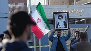 رجل عراقي يحمل صورة للمرشد الأعلى الإيراني آية الله علي خامنئي أمام السفارة الإيرانية، خلال تجمع لإظهار التضامن مع إيران ومعارضة التهديدات الأمريكية بشن ضربة عسكرية، في بغداد،