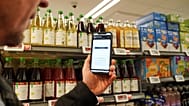 Ian Rosenfeldt, the creator of "Made O'Meter" mobile app, demonstrates how shoppers can use the application to identify American goods in a grocery store in Copenhagen.