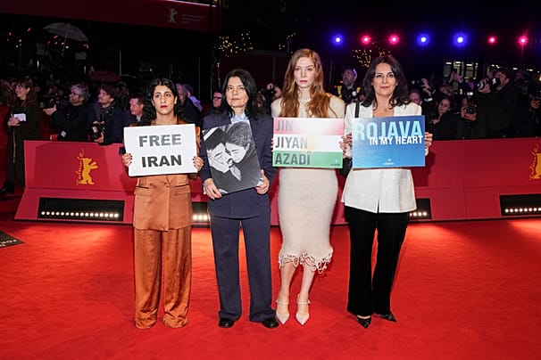 دُزن تکال، نویسنده و روزنامه‌نگار، بنفشه هورمزد، یاسمین طباطبایی و فلینه روگان پلاکاردهایی در حمایت ایران و رژواوا در دست دارند 