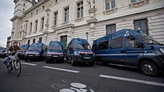 Велосипедист проезжает мимо машин французской полиции у здания уголовного суда на набережной Орфевр в Париже, понедельник, 16 ноября 2015 года.