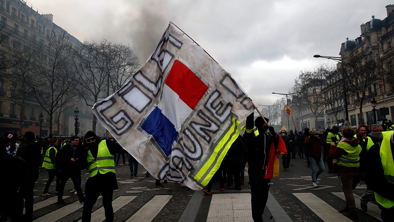 Un manifestant brandit une banderole "Gilets jaunes" lors d'une manifestation des Gilets jaunes, le samedi 16 mars 2019 à Paris.
