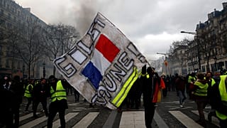 Un manifestant brandit une banderole "Gilets jaunes" lors d'une manifestation des Gilets jaunes, le samedi 16 mars 2019 à Paris.