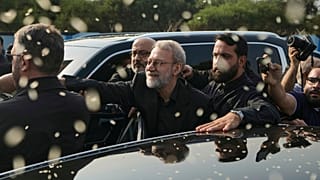 صورة أرشيفية - علي لاريجاني، في الوسط، سكرتير المجلس الأعلى للأمن القومي الإيراني، يلوّح بيده بينما يقوم أنصار حزب الله برمي الأرز للترحيب به خارج مطار رفيق الحريري الدولي في 