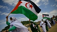 Manifestantes saharauis izan sus banderas en una concentración a lo largo de la playa de la Concha en apoyo de Brahim Ghali, líder del Frente Polisario.