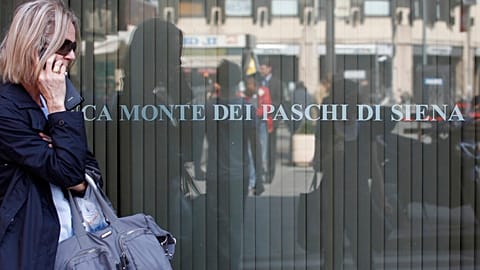 FILE. A woman walks past a Monte Dei Paschi di Siena bank branch in Milan, Italy. 17 Oct. 2016.