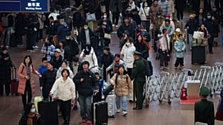 Des voyageurs se pressent dans le hall d'une gare alors qu'ils rentrent chez eux pour les vacances du Nouvel An lunaire, à Pékin, en Chine, le mardi 10 février 2026.