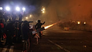 Vermummte junge Demonstrierende zünden Fackeln und Feuerwerk. Vor dem Büro des Premierministers protestieren sie gegen Korruption und die Politik der Regierung.