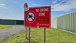 Um sinal de proibição de drones no exterior do perímetro do Aeroporto Internacional de Bruxelas, em Zaventem, Bélgica, depois de ter sido registada atividade nocturna de drones sobre o aeroporto em novembro de 2025.