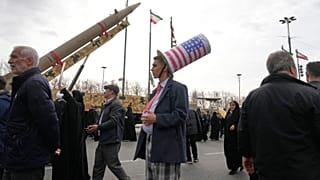 Tahran'daki Özgürlük Meydanı'nda 1979 İslam Devrimi anısına düzenlenen bir miting sırasında İran yapımı bir füzenin önünde duran ve Sam Amca şapkası takan bir adam, 11 Şubat 2026