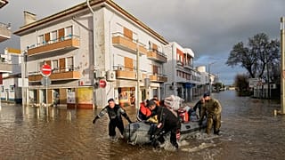 Police officers and marines evacuate residents from a hotel by inflatable boat in Alcácer do Sal, 6 February, 2026