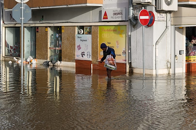 A man walks along a flooded street after the Sado River overflowed following heavy rains in Alcácer do Sal, 6 February, 2026