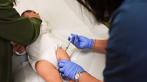 Lead medical assistant Maria Teresa Diocales administers a measles, mumps and rubella (MMR) vaccine.