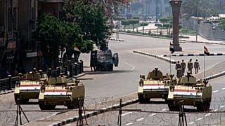 جنود الجيش المصري يتمركزون فوق مركباتهم المدرعة وبجوارها لحراسة مدخل ميدان التحرير في القاهرة، مصر، الجمعة 25 أبريل/نيسان 2014. (صورة من وكالة أسوشيتد برس/صبري خالد، صحيفة الش