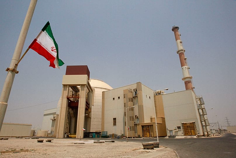 An Iranian flag flutters in front of the reactor building of the Bushehr nuclear power plant, 21 August, 2010