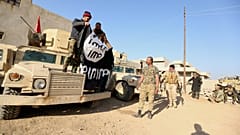 جنود من الجيش العراقي يرفعون علم داعش بعد مصادرته خلال عملية عسكرية في الموصل، بتاريخ 29 نوفمبر 2016.