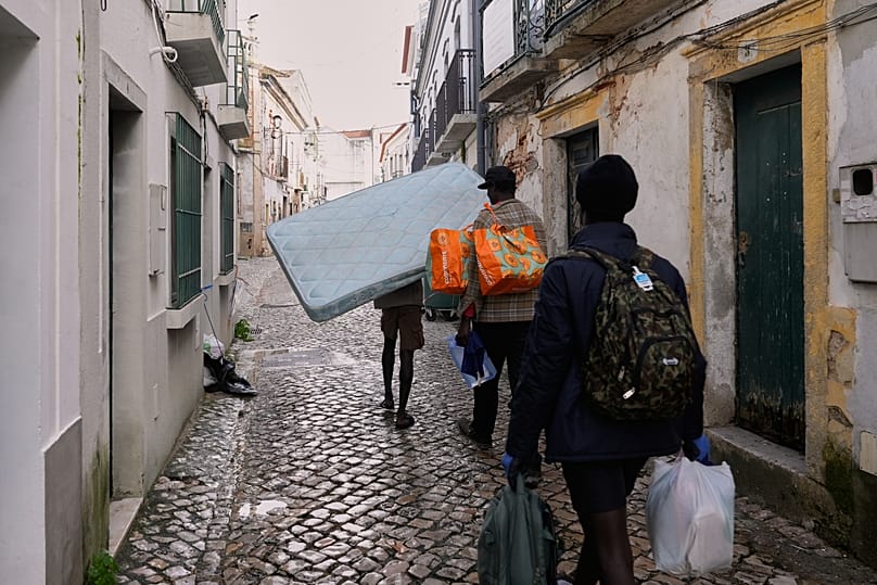 Moradores carregam os seus pertences numa rua após o Sado transbordar. Alcácer do Sal, sexta-feira, 6 de fevereiro 2026
