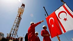 يقف عمال شركة النفط التركية (TPAO) أمام جهاز حفر قبل حفل بدء عمليات التنقيب عن النفط والغاز قرية سينيروستول/سينكراسي، يوم الخميس 26 أبريل/نيسان 2012.