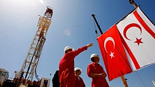 يقف عمال شركة النفط التركية (TPAO) أمام جهاز حفر قبل حفل بدء عمليات التنقيب عن النفط والغاز قرية سينيروستول/سينكراسي، يوم الخميس 26 أبريل/نيسان 2012.