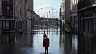 FILE: A boy stands in a flooded street as severe flooding hits western France amid storm Ivo, Thursday, Jan. 30, 2025