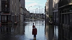 ARCHIV: Ein Junge steht in einer überfluteten Straße, als Sturm Ivo am Donnerstag, 30. Januar 2025, den Westen Frankreichs mit heftigen Fluten trifft.