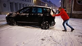 Un uomo spinge la sua auto durante una nevicata, Lille, Francia, 7 gennaio 2026
