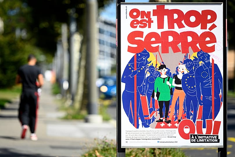 A poster of the Swiss People's Party (SVP) for a moderate immigration initiative reading 'we're too crowded!' in a street in Lausanne, 8 September, 2020
