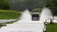 Auto fährt durch überflutete Straße in der Nähe von Marquartstein, 21. Mai 2019