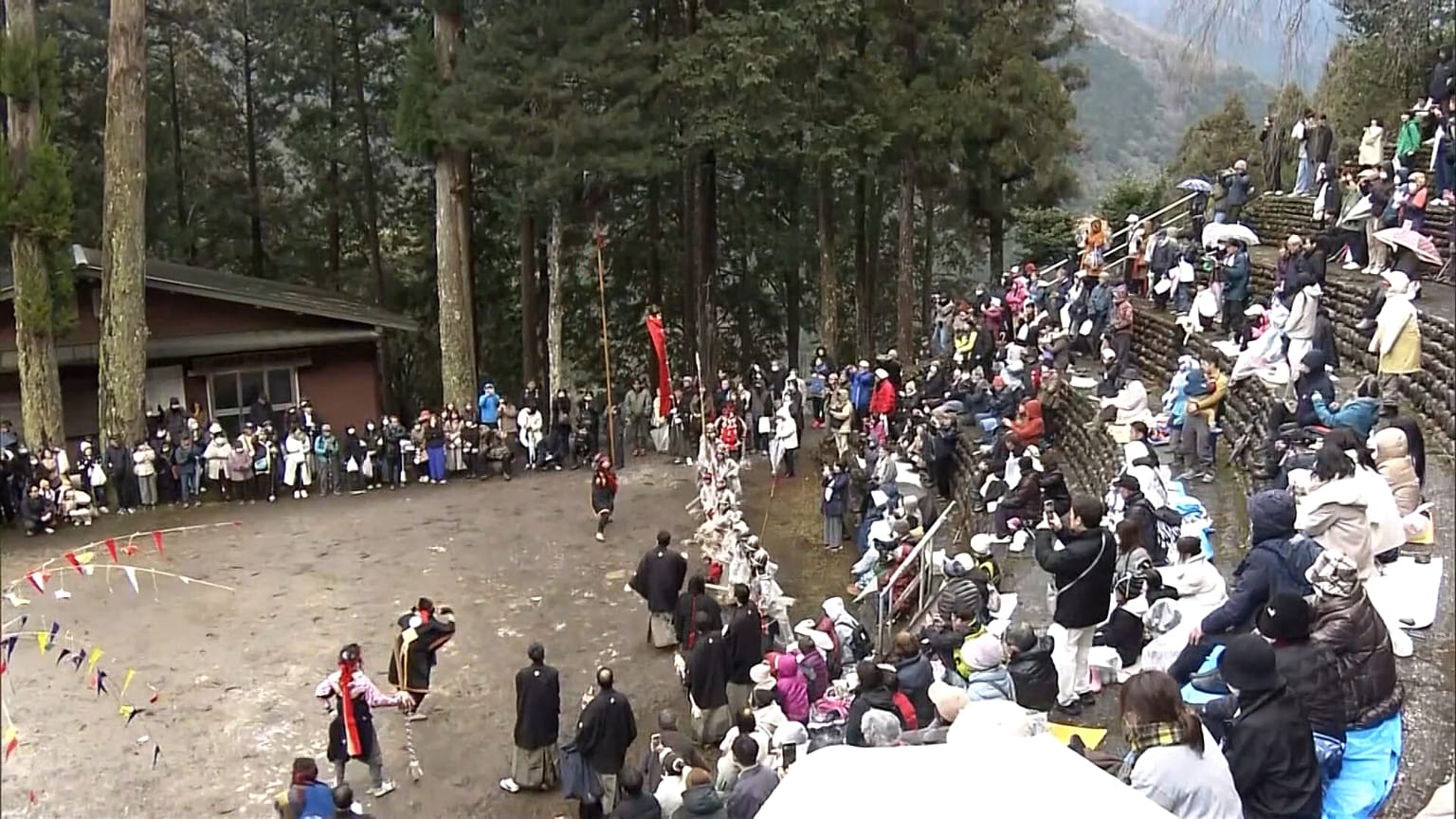 Zwei Männer schleudern einen sieben Meter langen Stab.