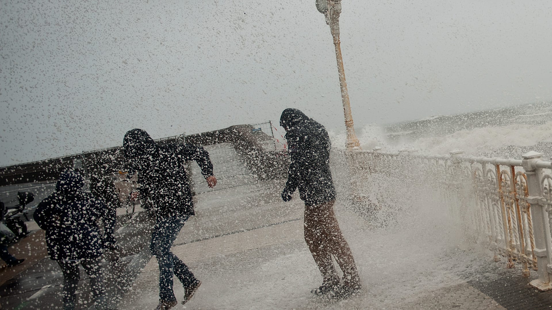 Menschen rennen bei Hochwasser auf der Promenade Paseo Nuevo in San Sebastian, Nordspanien, um sich vor dem Wasser zu schützen, 30. Januar 2015.