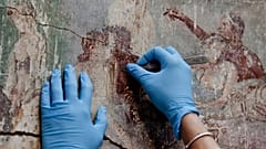 A restorer works on a detail of the "Casti Amanti" (Chaste Lovers) in a Roman villa at Pompeii 