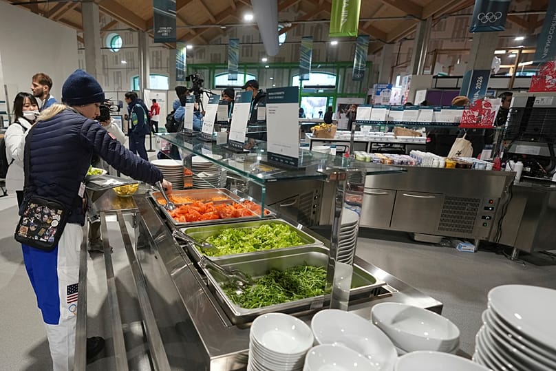 An athlete from the United States selects breakfast items inside the dining hall of the Olympic Village ahead of the 2026 Winter Olympics, in Milan, Italy.