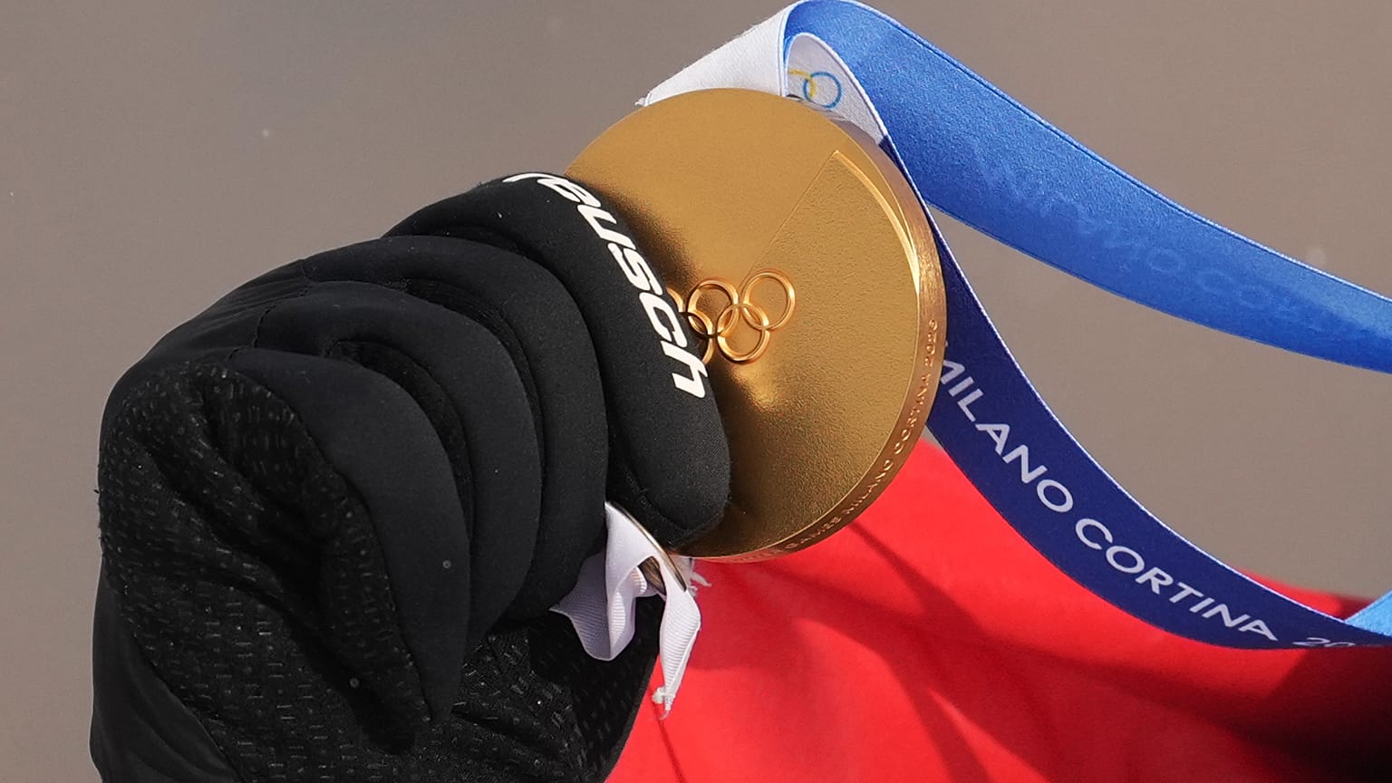 Austria's Alessandro Haemmerle holds his gold medal after winning the men's snowboard cross finals at the 2026 Winter Olympics, in Livigno, Italy, Thursday, Feb. 12, 2026.