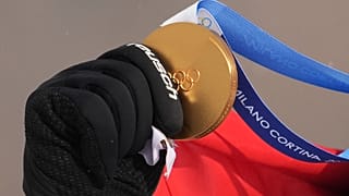 Austria's Alessandro Haemmerle holds his gold medal after winning the men's snowboard cross finals at the 2026 Winter Olympics, in Livigno, Italy, Thursday, Feb. 12, 2026.
