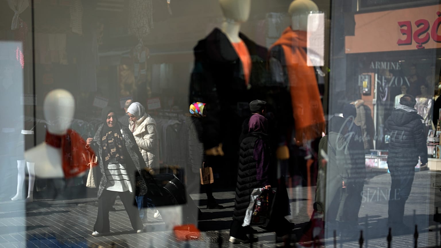 ينعكس المارة على زجاج واجهة متجر ملابس في منطقة إمينونو التجارية بإسطنبول، تركيا، الأربعاء 21 فبراير/شباط 2024. أبقى البنك المركزي التركي سعر الفائدة الرئيسي دون تغيير عند 45%