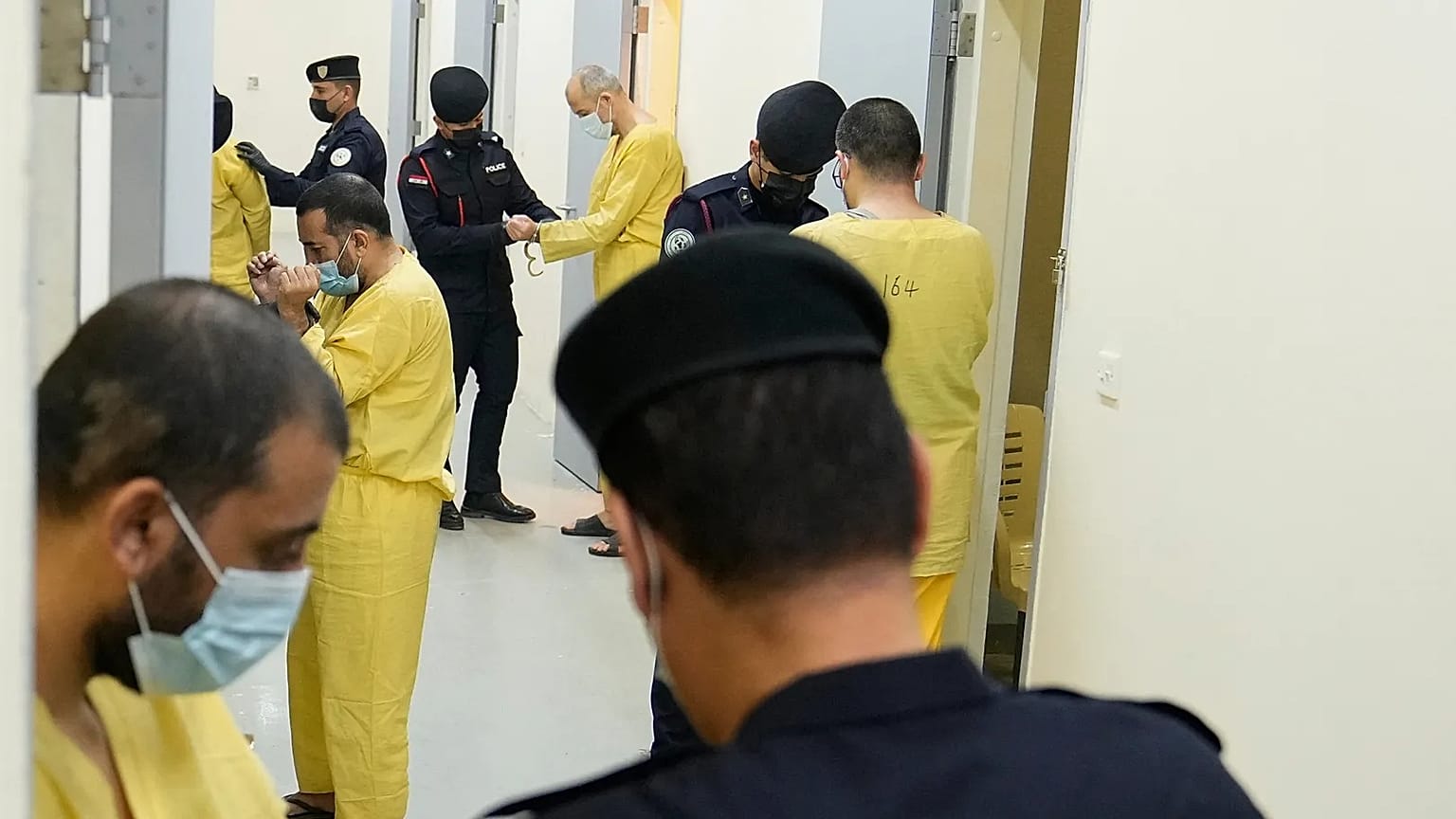 قوات الأمن العراقية تقود عناصر يُشتبه بانتمائهم لتنظيم الدولة الإسلامية لاستجوابهم، بعد نقلهم من سوريا إلى العراق، في سجن الكرخ المركزي في بغداد، العراق