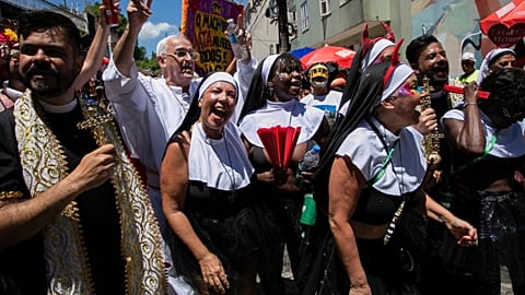Revelers dressed as priests and nuns dance during the Carmelitas street party