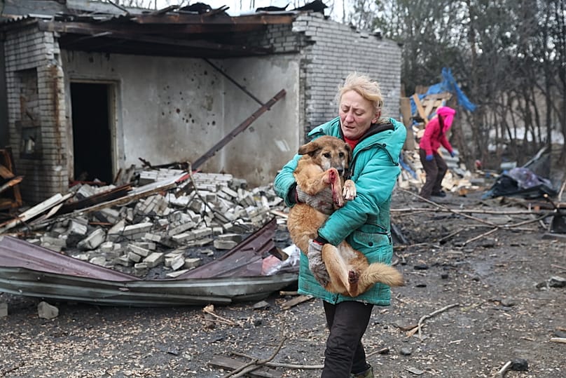 Des personnes évacuent des chiens blessés après qu'une frappe aérienne russe a touché un refuge pour chiens errants à Zaporijjia, en Ukraine, le 6 février 2026. 