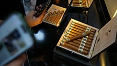 Des visiteurs photographient des cigares exposés lors du XXVe Festival du cigare au Palais des congrès de La Havane, à Cuba, le mardi 24 février 2025.