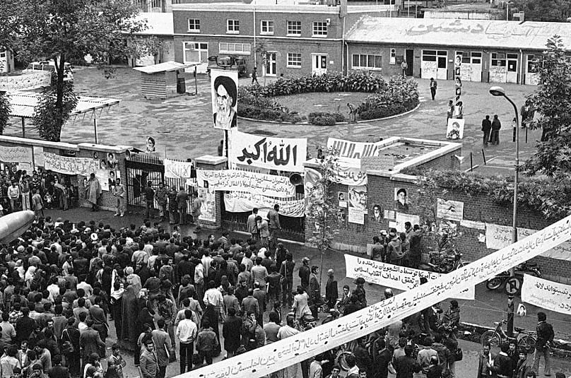 طهران (6 نوفمبر/تشرين الثاني 1979): تجمع إيرانيون أمام مدخل مجمع السفارة الأميركية في العاصمة الإيرانية، بعد أيام من اقتحامها وبدء أزمة الرهائن.