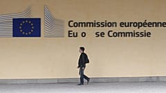 Vor dem Gebäude der EU-Kommission geht ein Mann die Straße entlang.