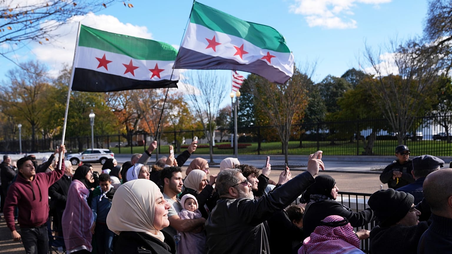 سوريون يتجمعون لدى وصول الرئيس السوري الانتقالي أحمد الشرع بواشنطن، في 10 نوفمبر 2025.