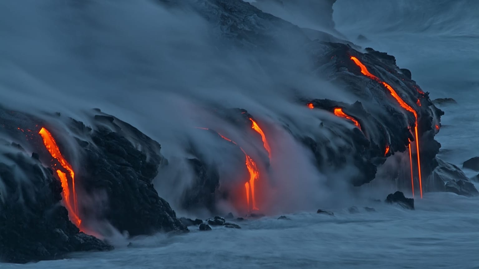 FILE:Lava from Kilauea volcano in Hawaii Volcanoes National Park enters the Pacific Ocean at dawn Wednesday, Feb. 2, 2005