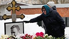 Die Mutter des verstorbenen russischen Oppositionspolitikers Alexej Nawalny, Ljudmila Nawalnaja, berührt an seinem Grab sein Porträt.