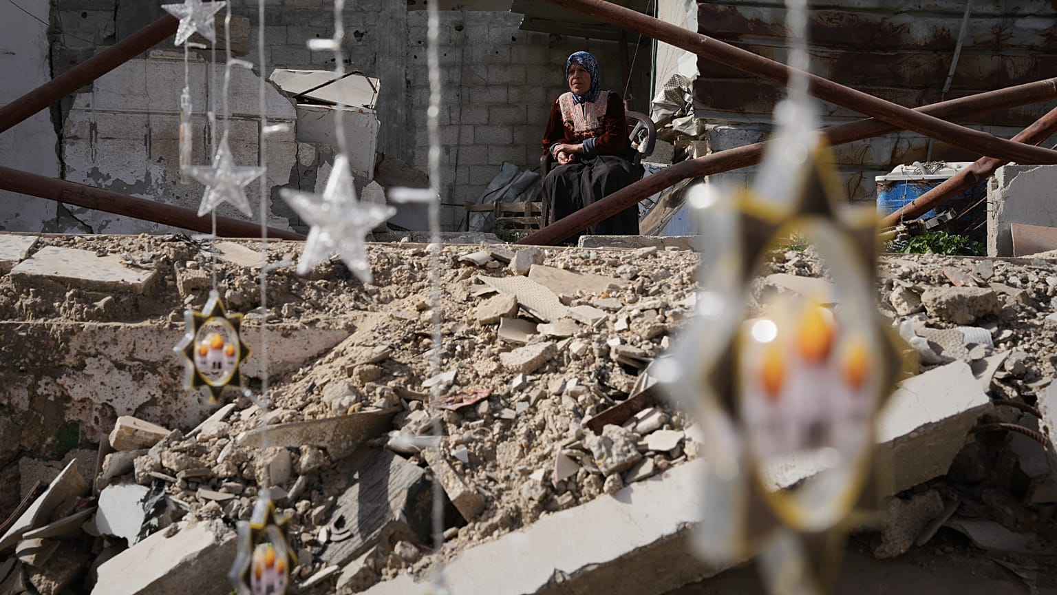 زينة رمضان معلّقة إلى جانب أنقاض منازل مدمّرة في خان يونس جنوب قطاع غزة استعدادًا لاستقبال شهر رمضان.