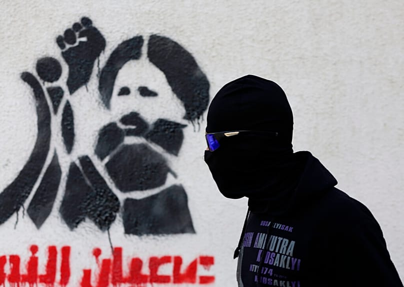 متظاهر بحريني ملثم مناهض للحكومة، يترقب تحركات الشرطة خلال اشتباكات في سترة، البحرين، الأحد 14 فبراير/شباط 2016. 