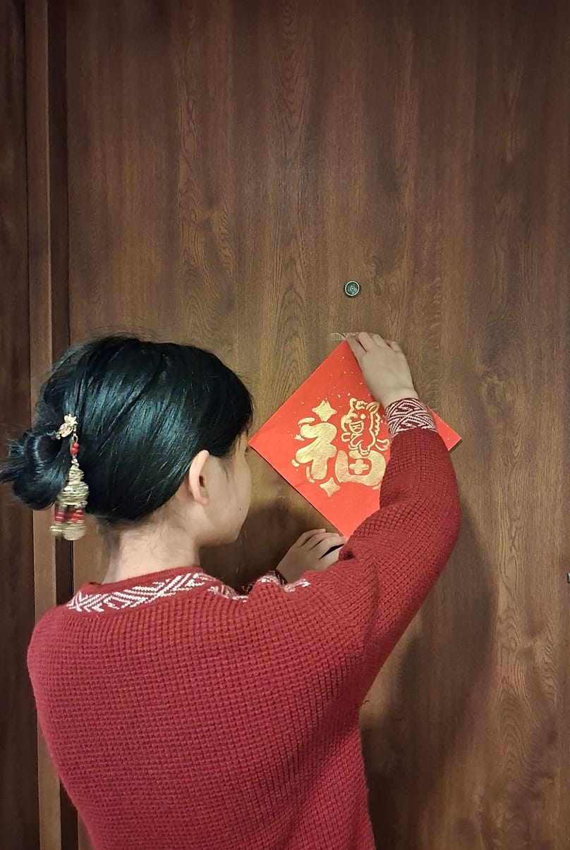 Przy drzwiach wejściowych wieszane są chunlian 春联 – symetryczne pary napisów po obu stronach drzwi, a nad drzwiami często jeszcze dodatkowy poziomy napis (hengpi).