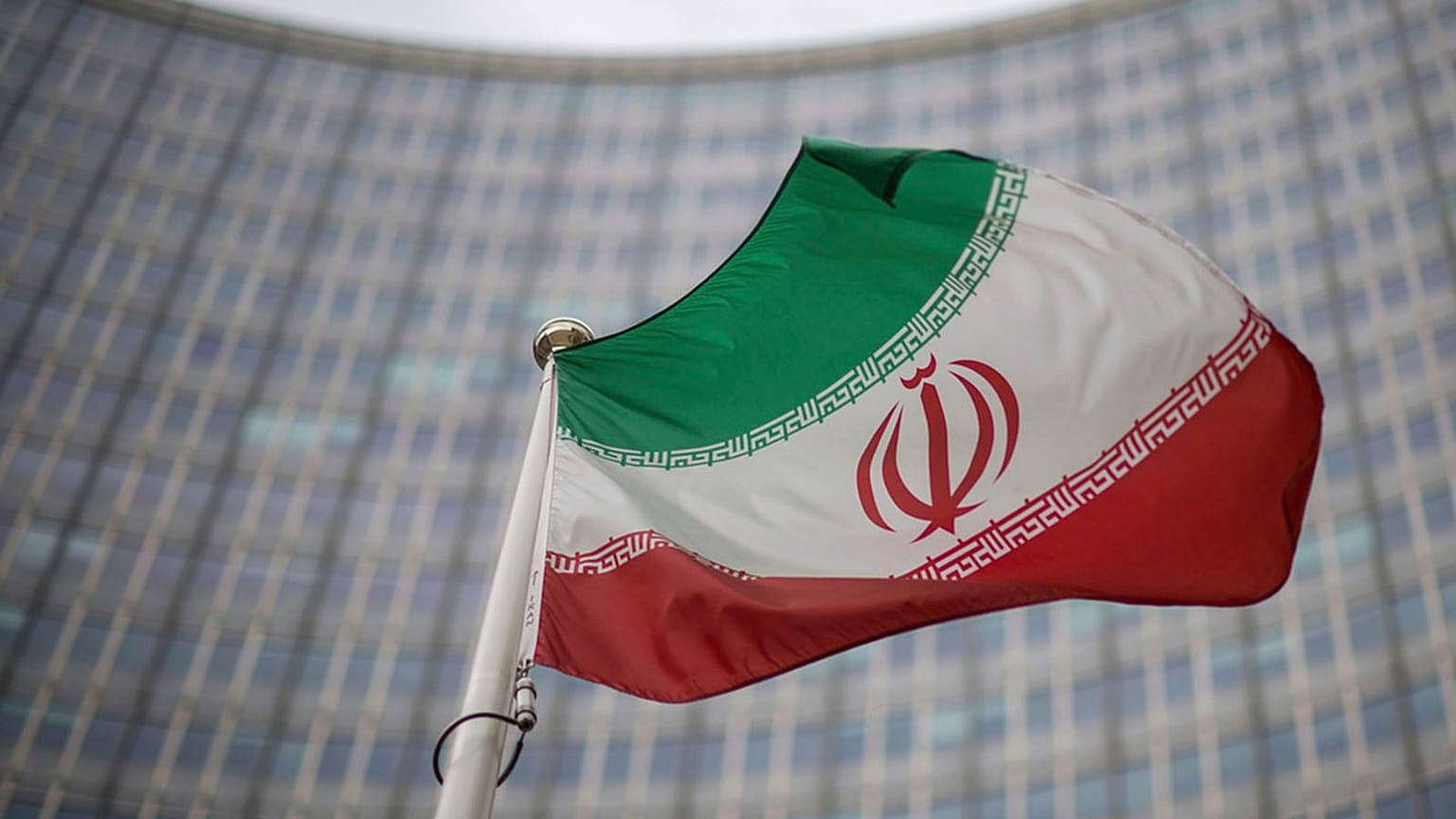FILE: A national flag of Iran waves in front of the building of the International Atomic Energy Agency, IAEA, in Vienna, 17 December 2021