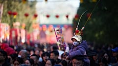 Ein Kind mit Festkopfschmuck sitzt auf den Schultern eines Erwachsenen bei einem Tempelfest zum Mondneujahr in Peking, China, am Dienstag, 17. Februar 2026.