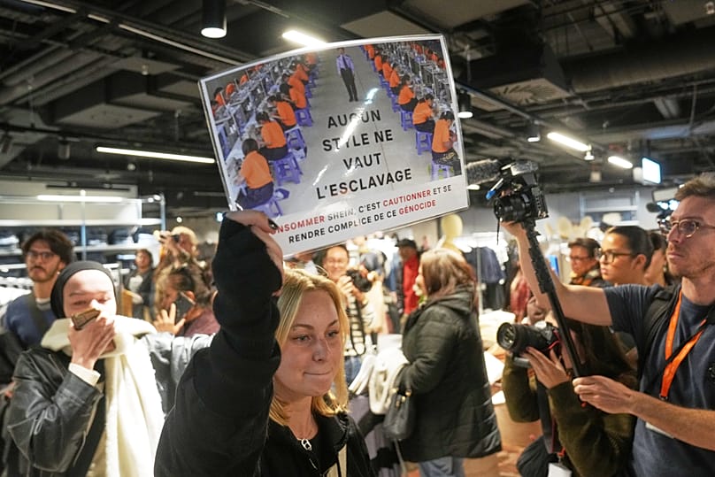 Eine Demonstrantin hält im Warenhaus BHV ein Schild mit der Aufschrift "No style worth slavery", als der Fast-Fashion-Konzern Shein am Mittwoch, dem 5. November 2025, seinen ersten stationären Laden eröffnet.