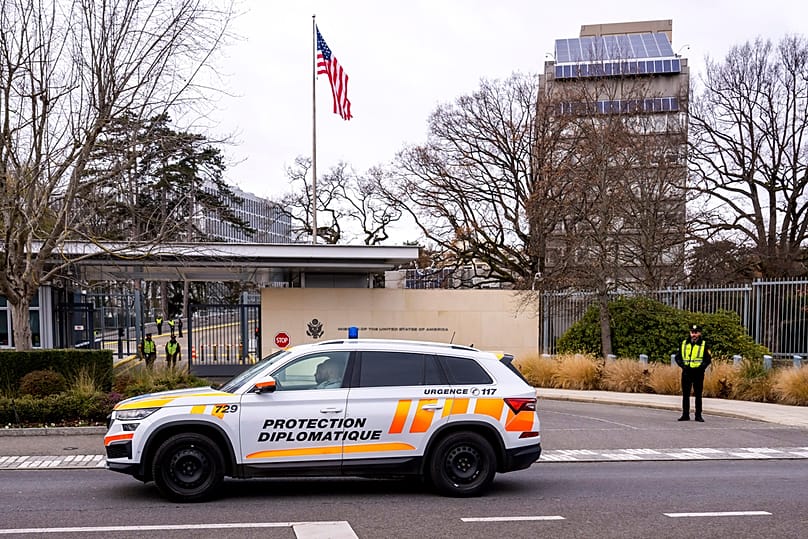 A car from the diplomatic police protection unit drives past the entrance of the US Permanent Mission in Geneva, 23 November 2025